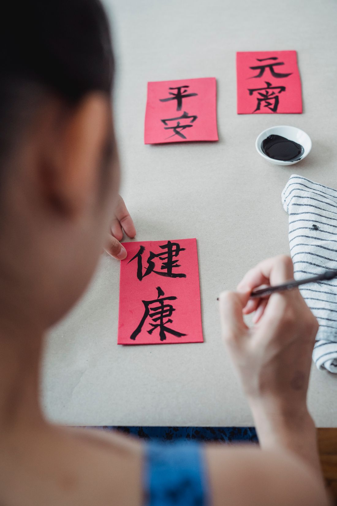 A learner writing Chinese characters with an ink brush